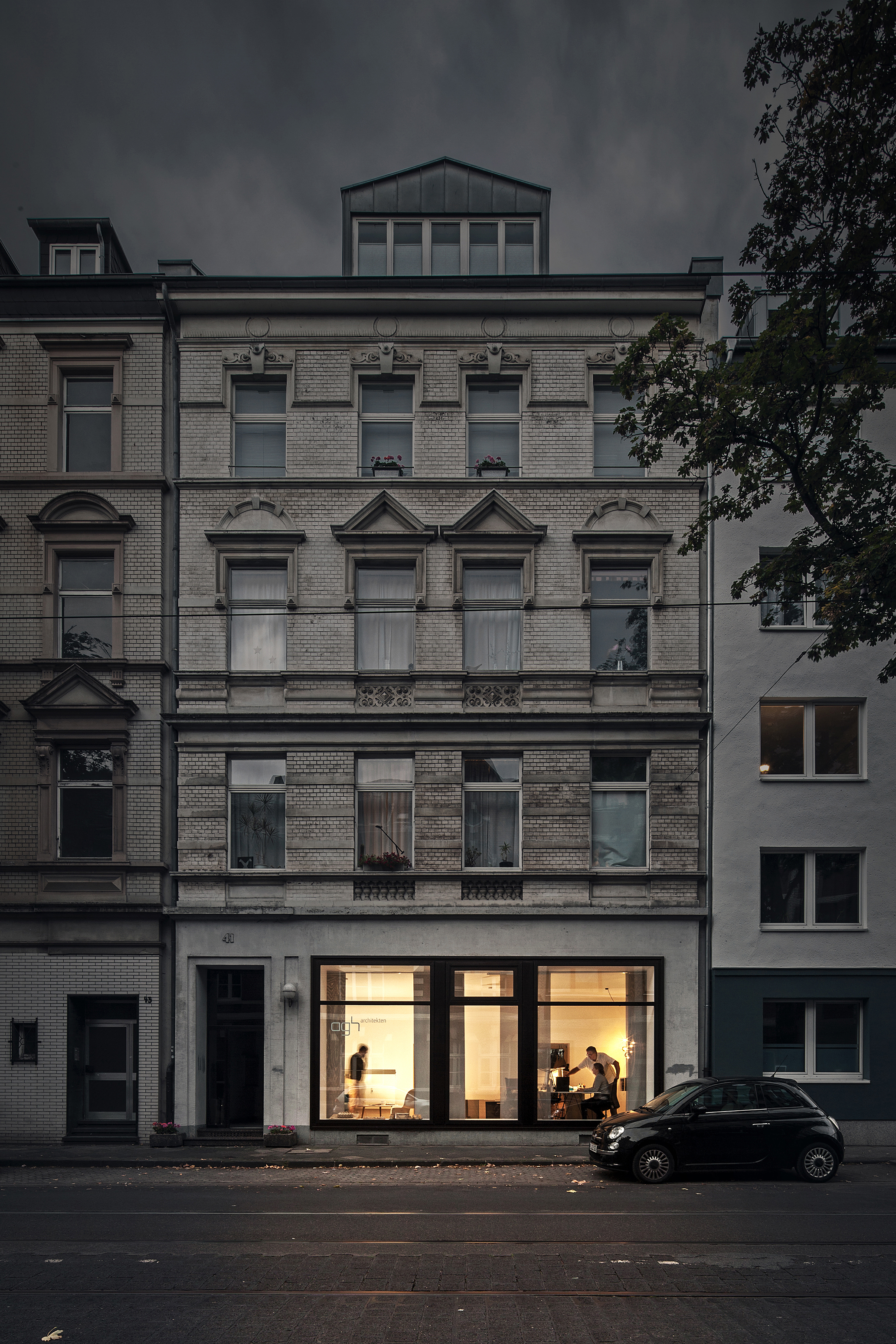 Außenansicht von agh architekten an der Blücherstraße 41 mit beleuchtetem Büro im Erdgeschoss